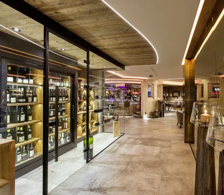 Gang entlang der Vinothek zur Bar im Tuxerhof mit großen Kerzenständern