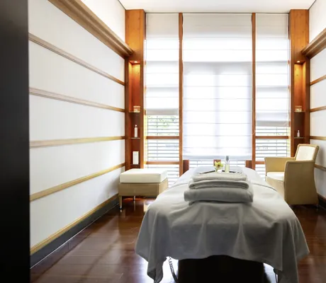 Behandlungsraum im Victoria-Jungfrau mit Korbstuhl und heruntergelassenen Rollos