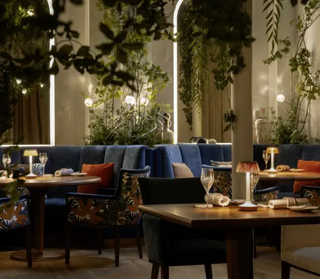 eingedeckte Tische im Gourmetrestaurant Radius im Victoria-Jungfrau mit blauen Samtsofas