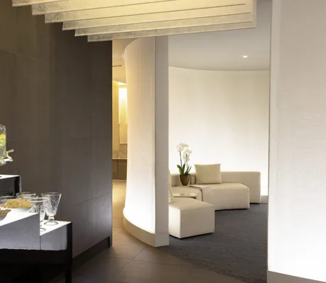 Empfangsbereich mit Wasserspender und Snacks und weißer Sofaecke im Victoria-Jungfrau