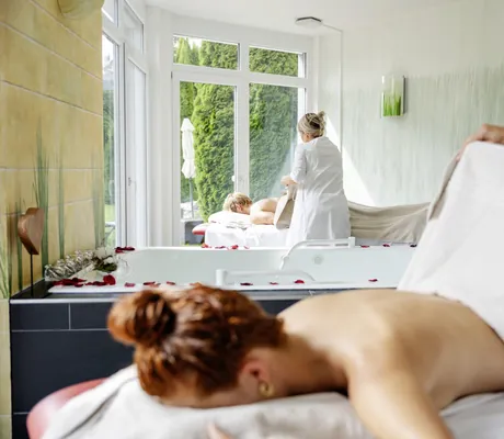 rothaarige Frau wird auf massageliege im Vier Jahreszeiten am Schluchsee von Therapeutin mit Handtuch zugedeckt