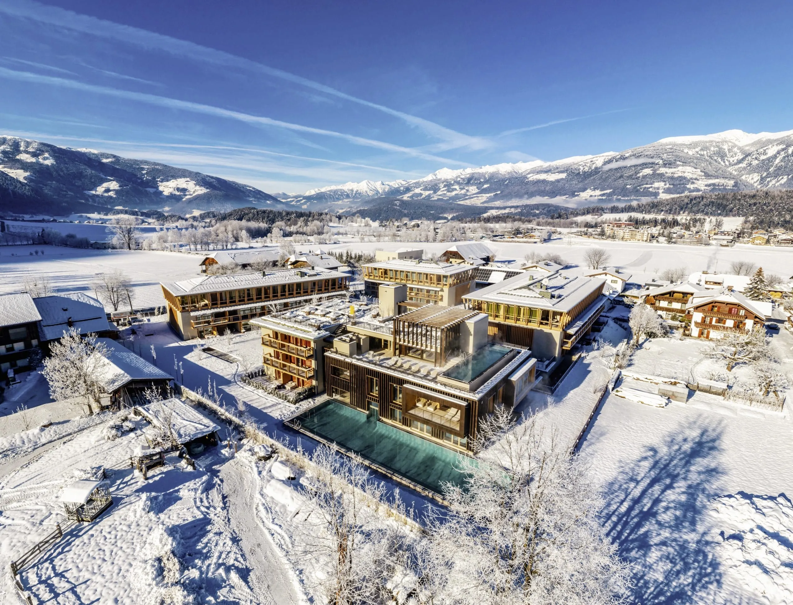 Gesamtansicht des Falkensteiner Hotel Kronplatz von oben im Schnee mit Blick in die Berge
