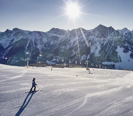 Piste und Lift am Kronplatz oberhalb des Falkensteiner Kronplatz bei strahlendem Sonnenschein