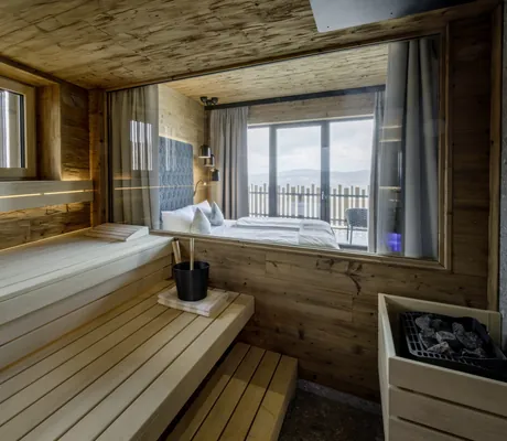 Blick von der privaten Sauna im Loft des Hunderesort Waldeck auf Bett und Balkon