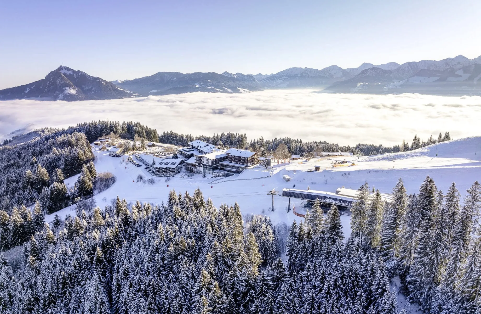 Hausansicht des Allgäuer Berghof im tiefen Schnee mit Blick auf die Alpen