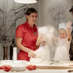 zwei Kinder in Kochoutfit backen mit ihren Eltern im Alpin SPA Hotel Tuxerhof Pizza