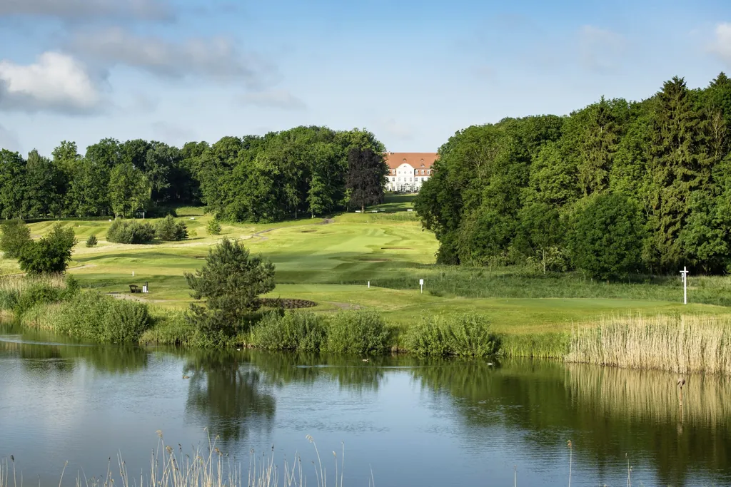 Golfplatz vor dem Hotel SCHLOSS Fleesensee mit See im Vordergrund und Blick auf das Schlosshotel