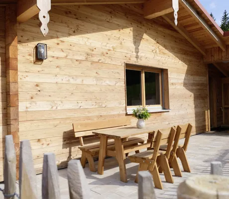 Terrasse am Cottage im Hunderesort Waldeck mit Blumenvase auf dem Holztisch