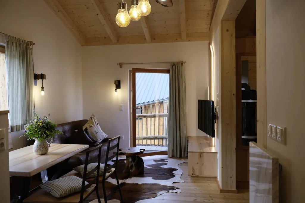 Blick in den Wohnraum des Cottages im Hunderesort Waldeck mit Kuhfellteppich