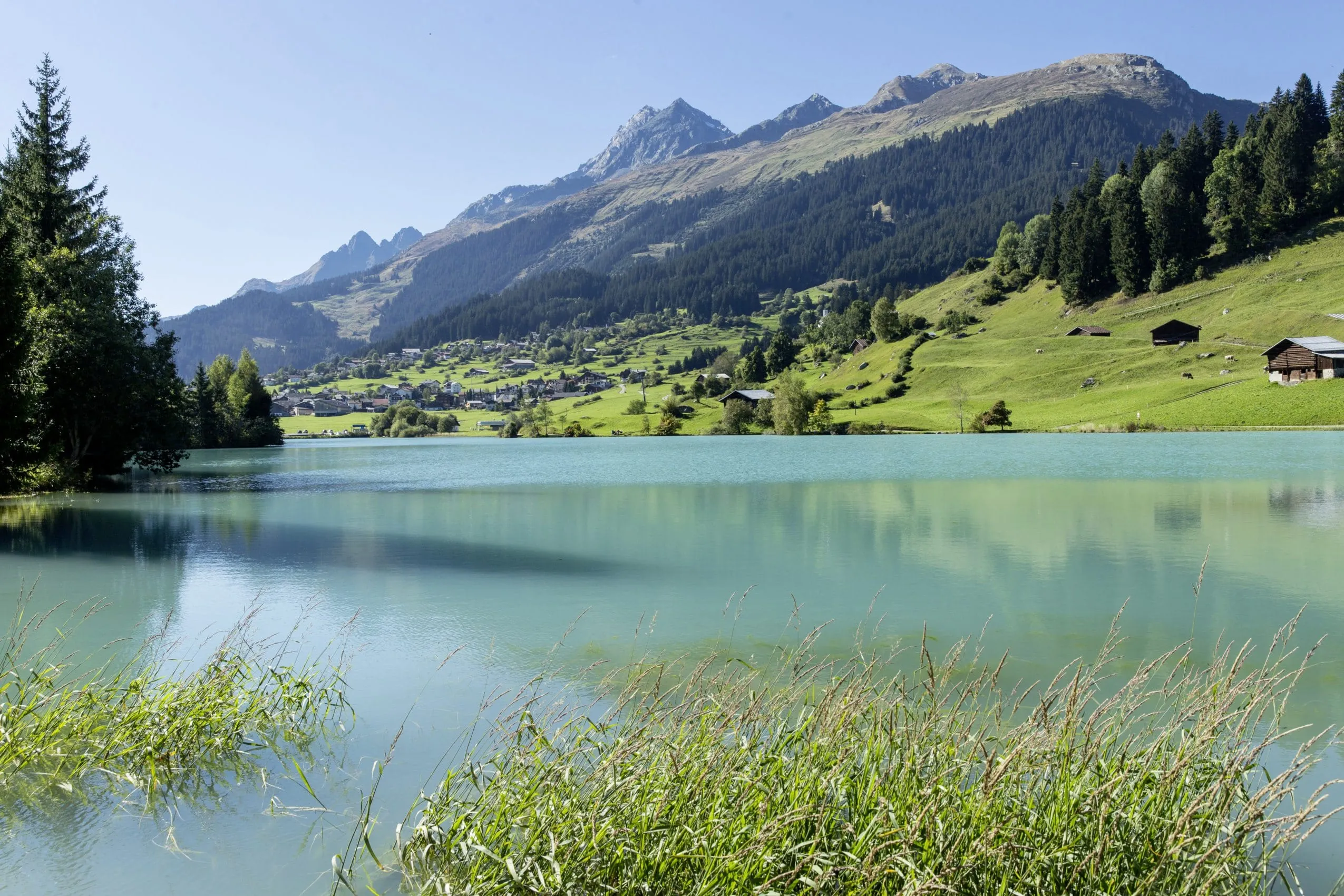 Blick &uuml;ber den Badesee hinweg auf das Dorf Brigels in der Schweiz
