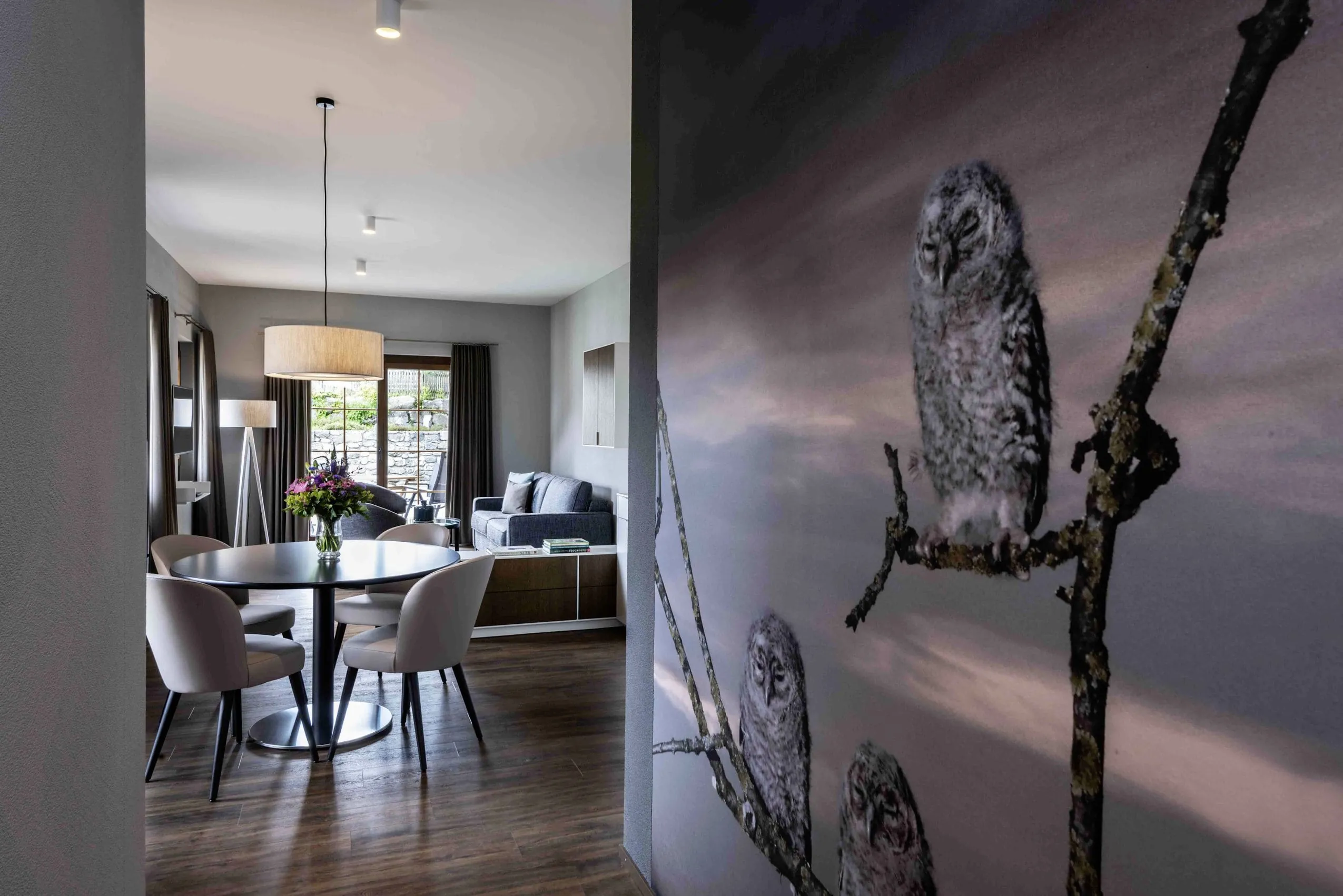 Blick in eine Suite im Hundehotel Mischun mit Wohn- und Essbereich und Tapete im Eingangsbereich