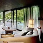 große Sitzlounge im Wohnzimmer der Amonti Chalets mit Kamin und Blick auf den privaten Pool
