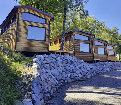 Blick von vorne auf die Tiny Houses des SEINZ Wisdom Resort mit jeweils großen Panoramafenstern