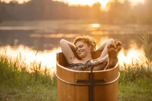 Junge Frau macht ein Moorbad in Badezuber aus Holz