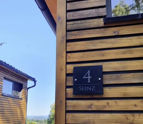 Tiny House des SEINZ Wisdom Resort mit Hausnummer und Holzterrasse