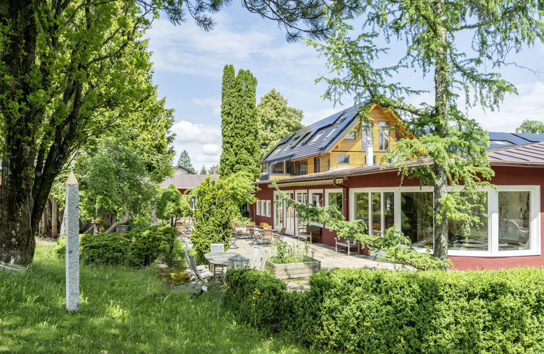 Außenansicht des SEINZ Wisdom Resort mit Terrasse und Obelisk im Garten