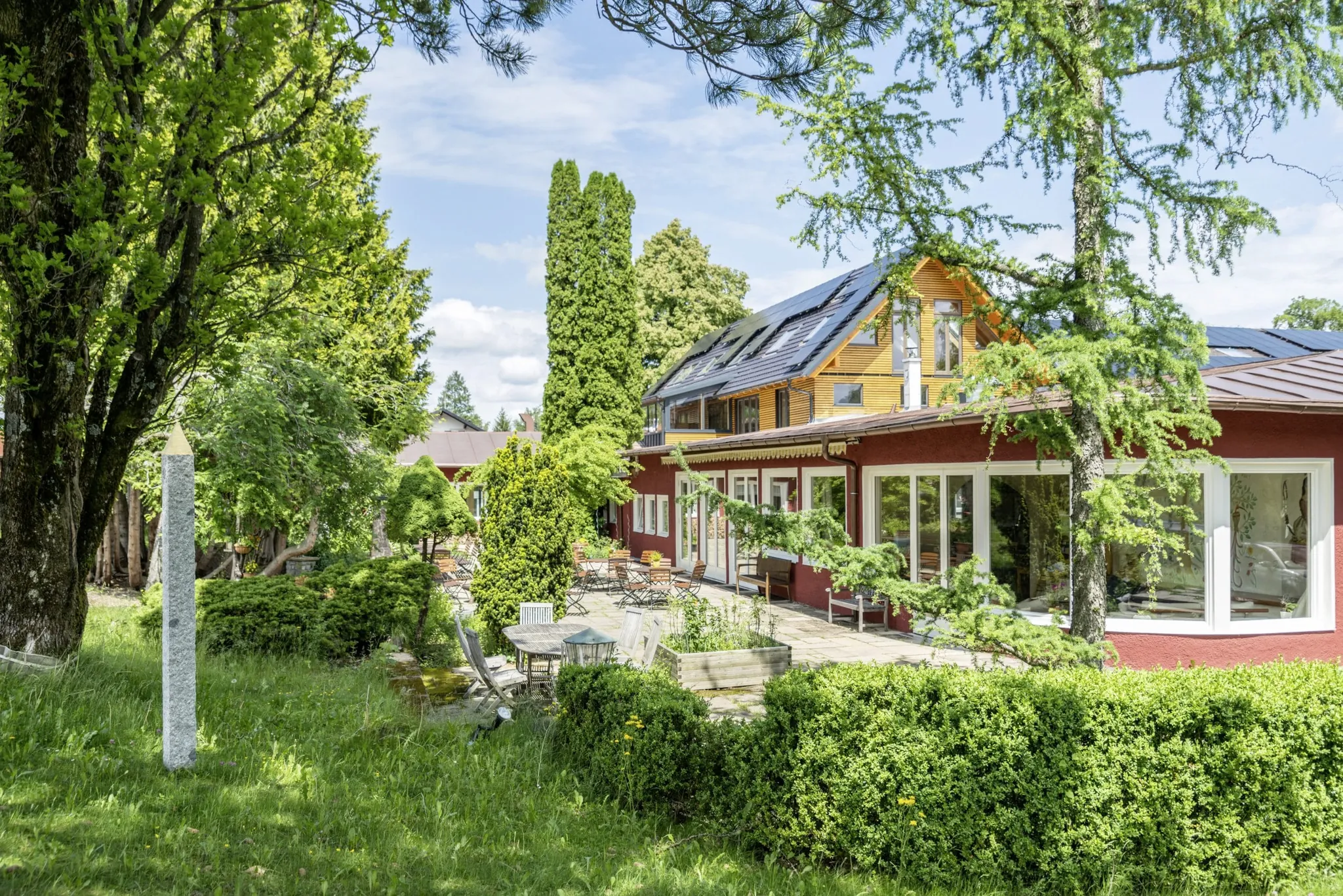 Außenansicht des SEINZ Wisdom Resort mit Terrasse und Obelisk im Garten