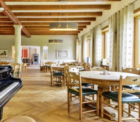 Restauarnt im SEINZ Wisdom Resort mit runden Tischen und Flügel in der Front