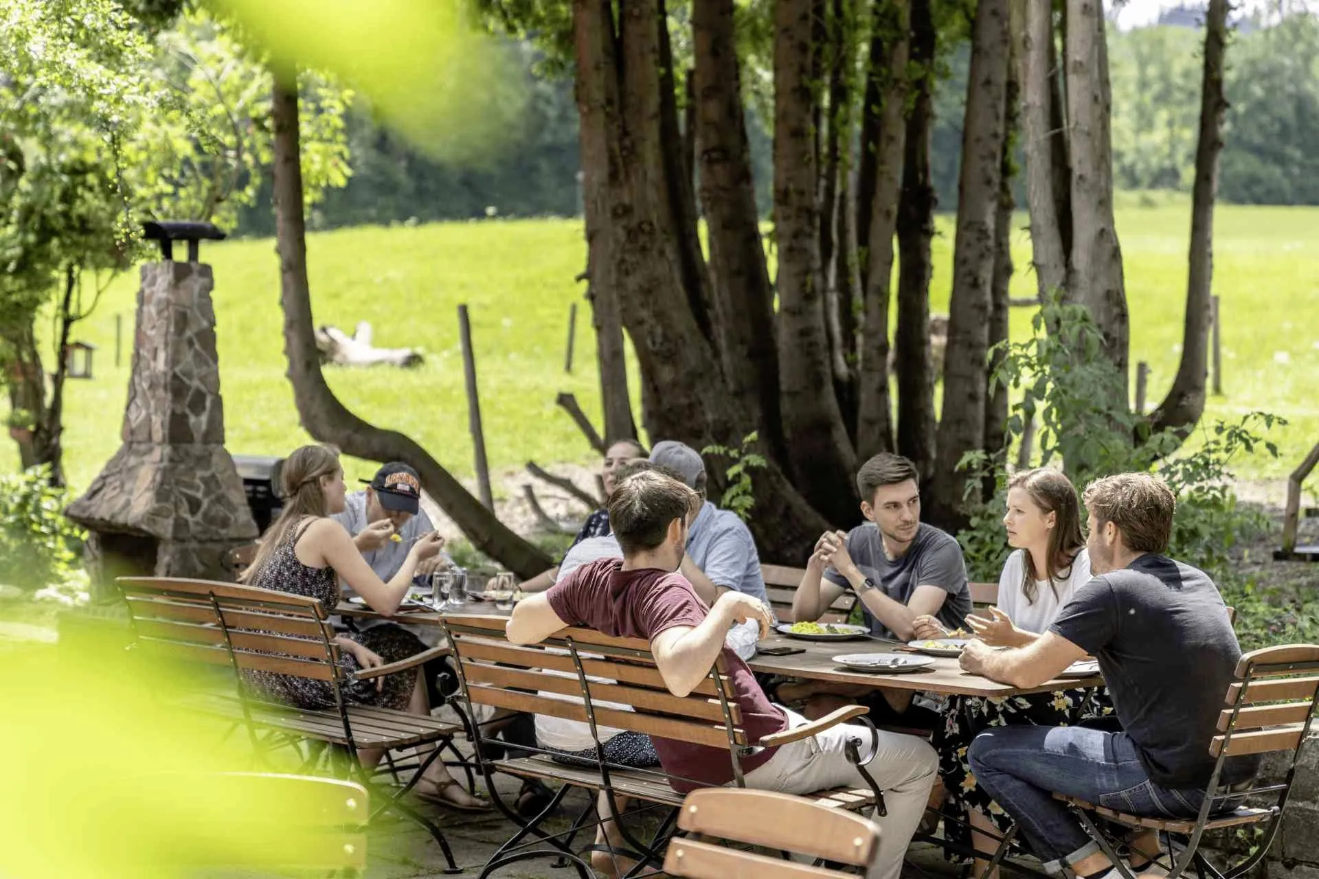 Gruppe von jungen Menschen sitzt auf der Terrasse des SEINZ Wisdom Resort beim Essen