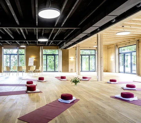 Yogamatten in großem Saal im SEINZ Wisdom Resort mit schwarzer Industriedecke