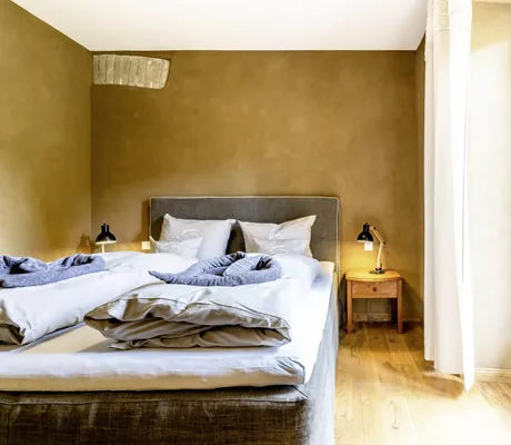 Zimmer im SEINZ Wisdom Resort mit freigelegter Mauer an der Wand und Leinenvorhängen