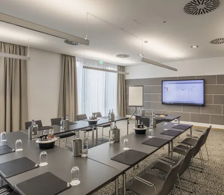 Tagungsraum in Wellings Parkhotel mit grauem Teppich und Monitor