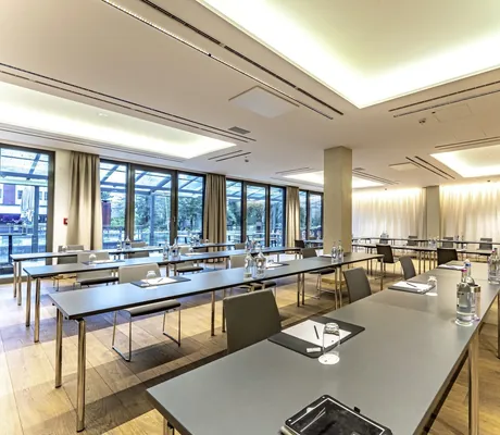 großer Tagungsraum mit schwarzen breiten Tischen im Wellings Parkhotel und Blick nach draußen