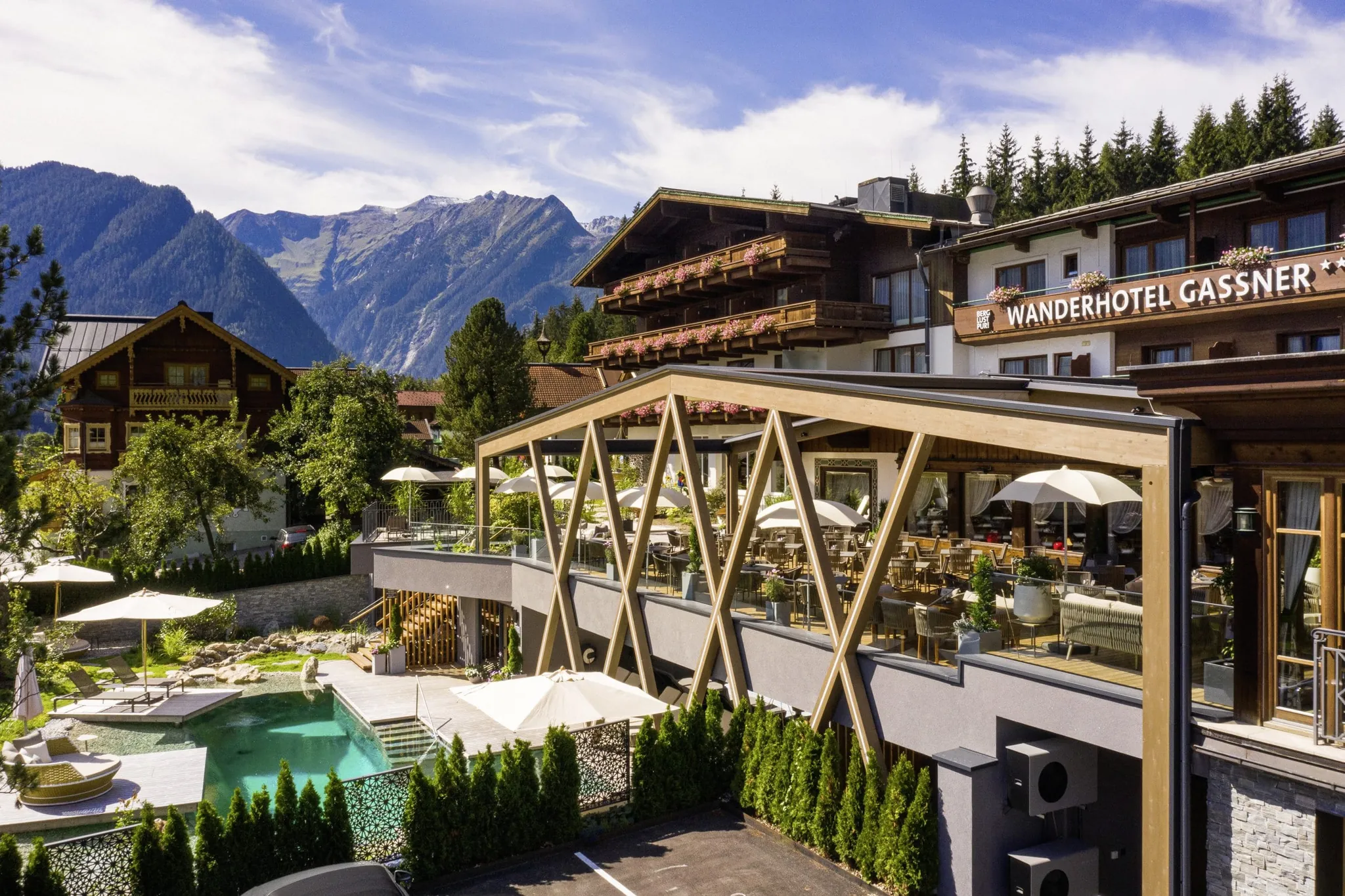 Wanderhotel Gassner in Neukirchen am Großvenediger mit Terrasse, Naturpool und Bergpanorama im Sommer