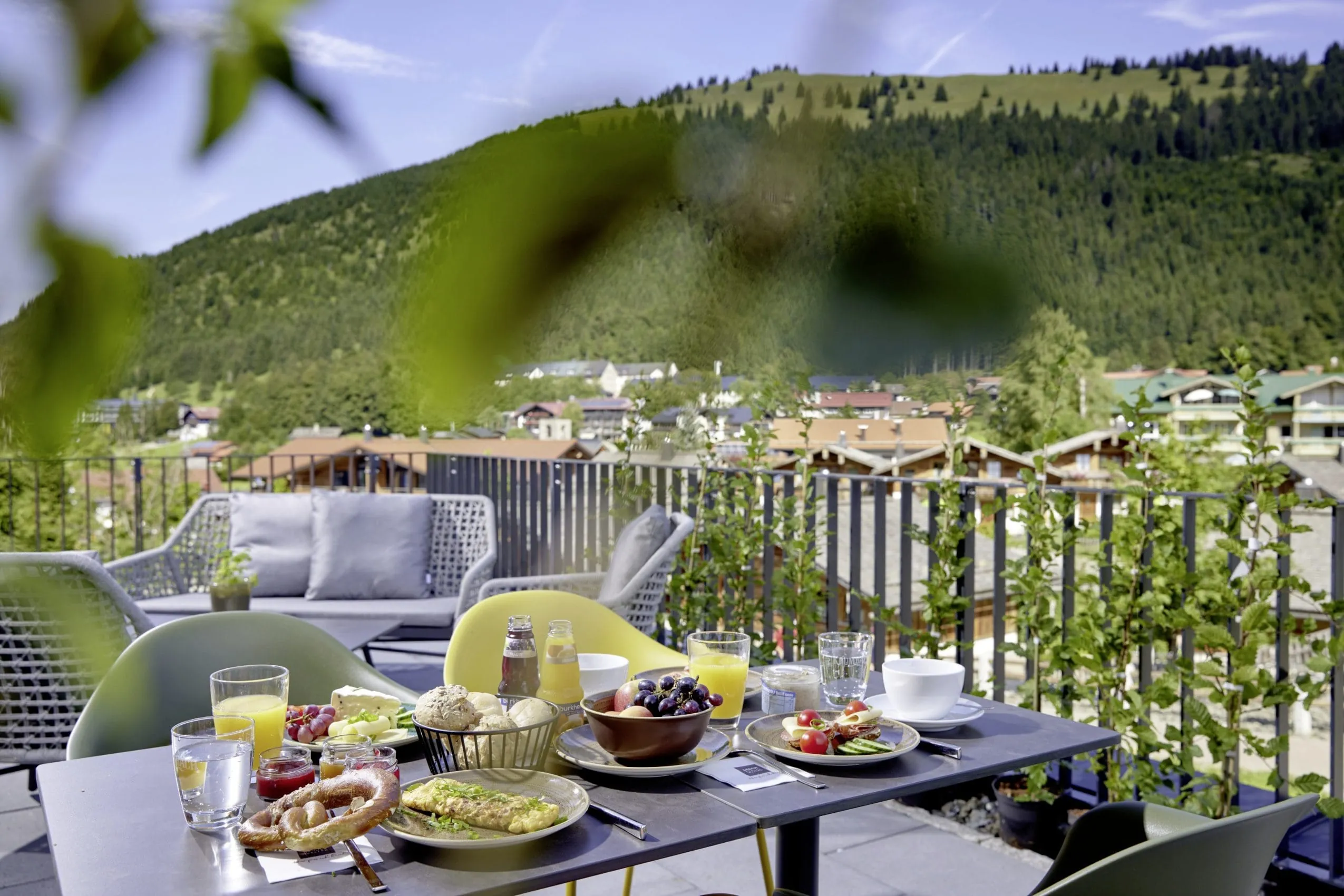 Gedeckter Fr&uuml;hst&uuml;ckstisch auf der Sonnenterrasse des BergBuddies-Hotel mit sehr viel Auswahl