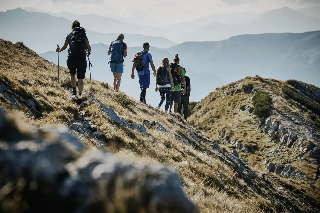 Wandergruppe auf Bergkamm mit Weitblick auf Alpenpanorama