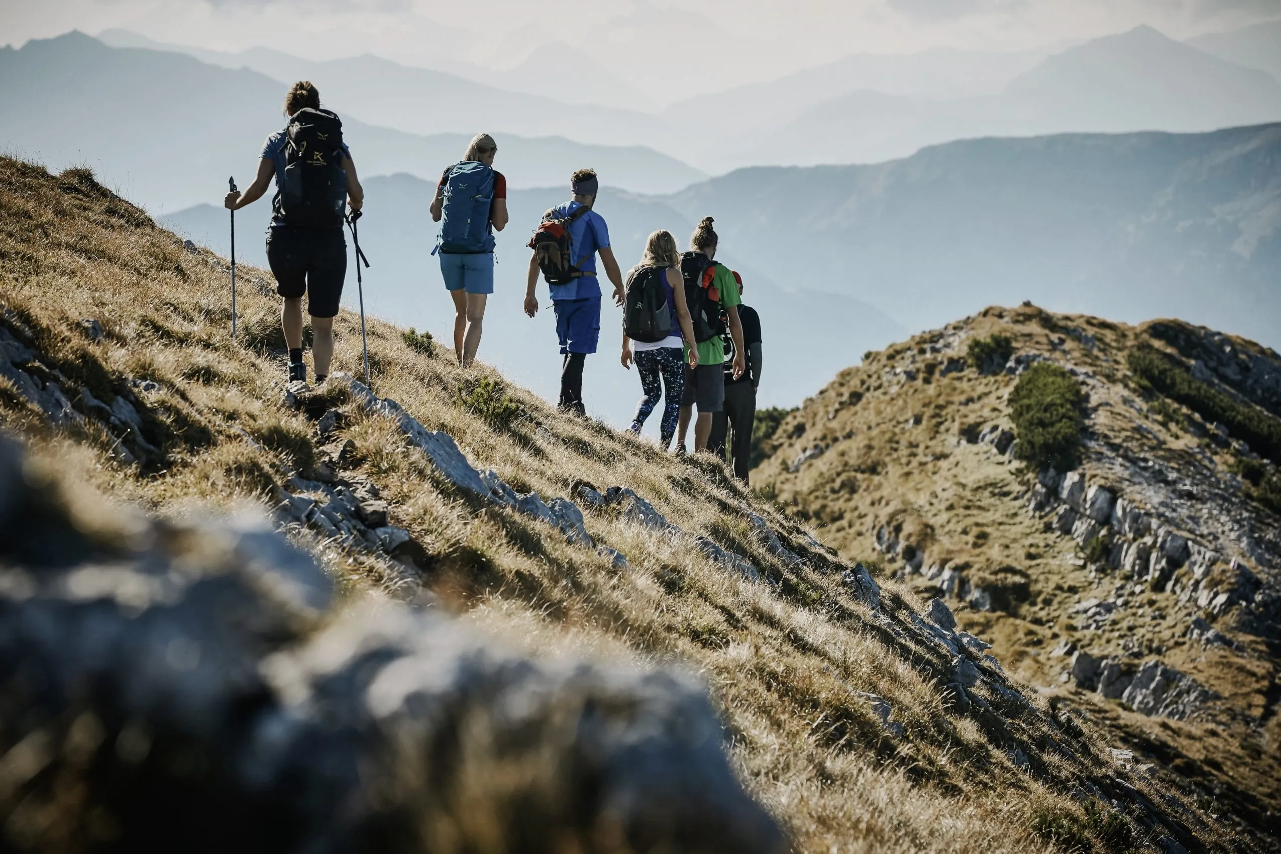 Wandergruppe auf Bergkamm mit Weitblick auf Alpenpanorama
