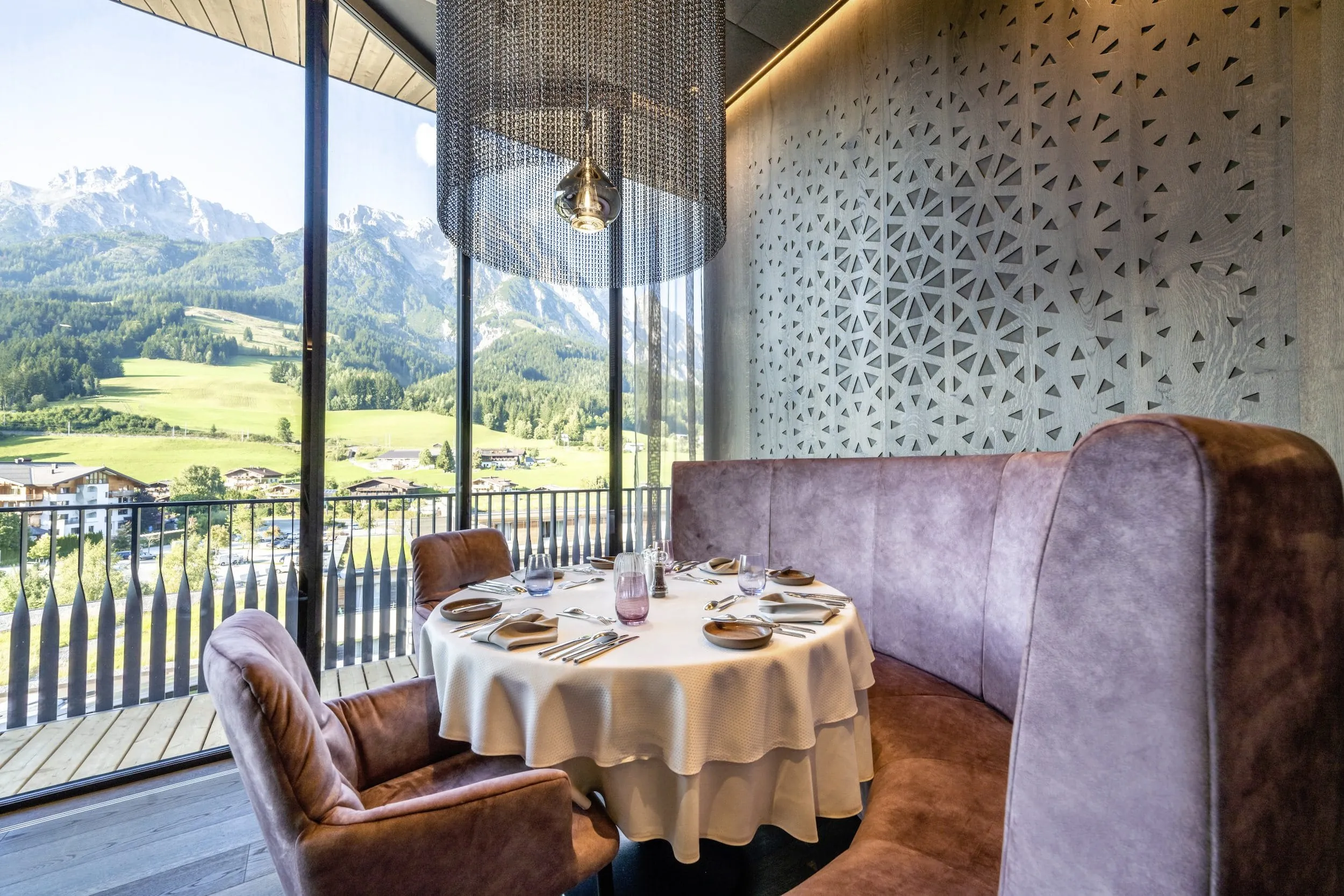 Gedeckter Tisch am Panoramafenster im Gourmetrestaurant Bergseele mit Bergblick im Good Life Resort Riederalm