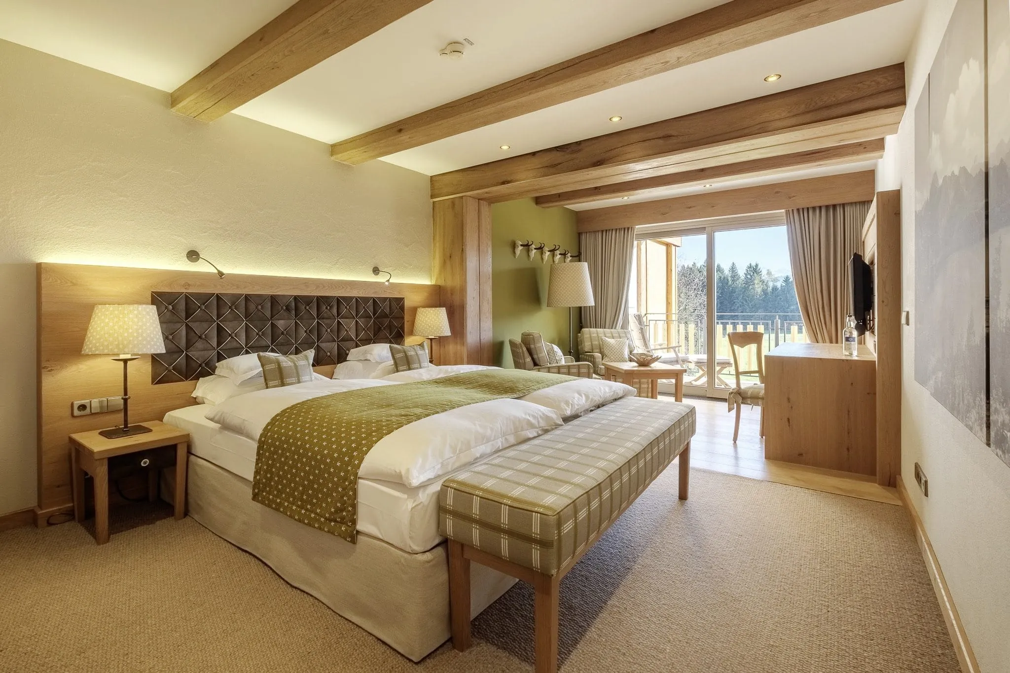 Gem&uuml;tlich eingerichtetes Zimmer mit vielen Holzelementen und Balkon im Wanderhotel Sonnenalp Resort