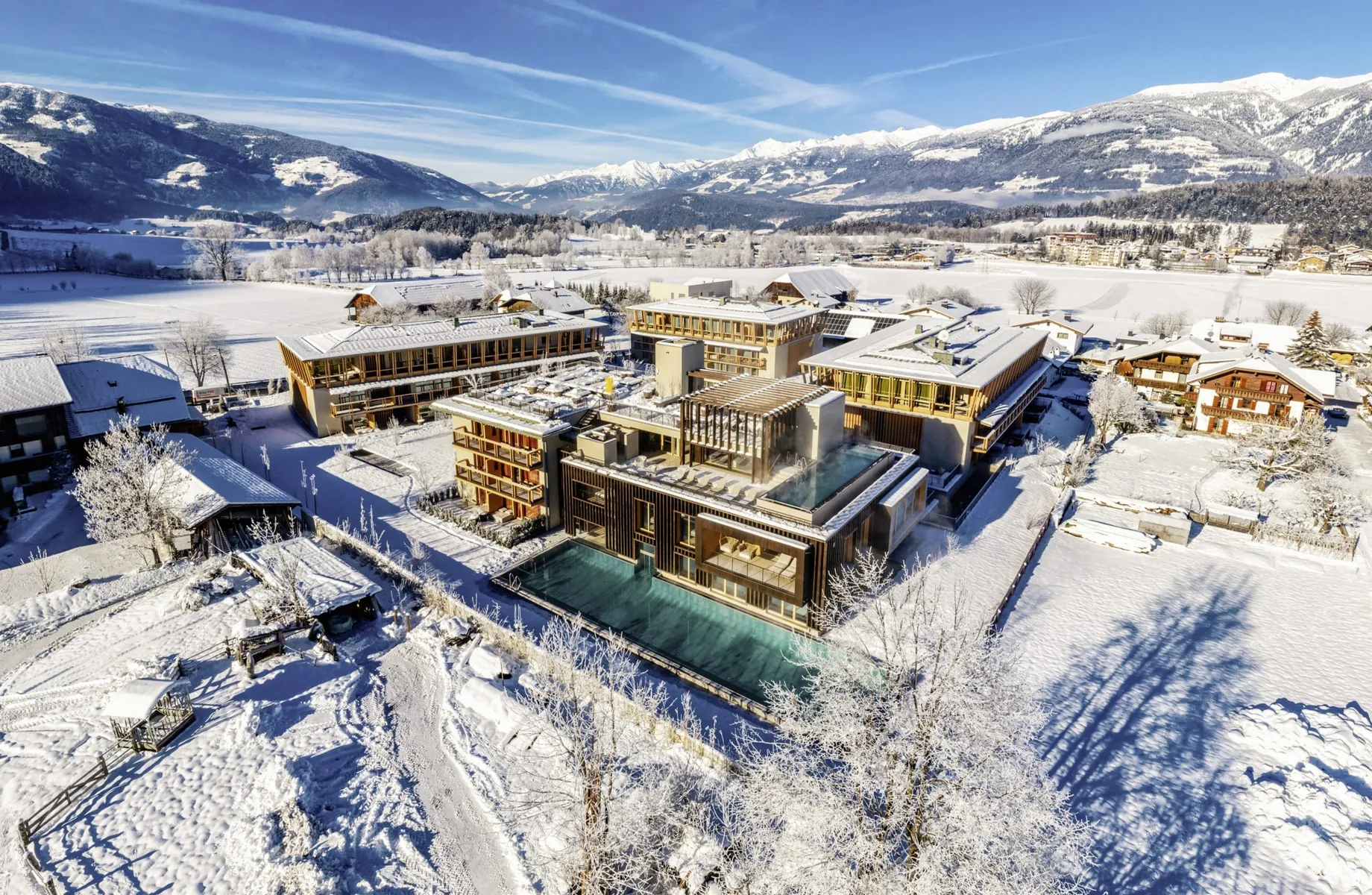 Gesamtansicht des Falkensteiner Hotel Kronplatz von oben im Schnee mit Blick in die Berge