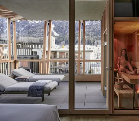 Frau sitzt in der privaten Sauna in der Suite des Falkensteiner Kronplatz