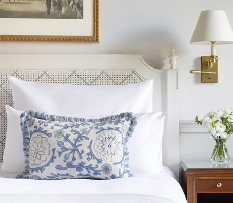 Detail Bett in Brenners Park-Hotel & Spa mit blaugemustertem Kissen und Blumenvase auf dem Nachttisch