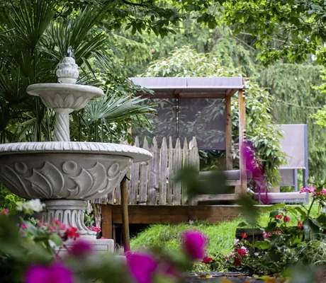 Springbrunnen unter Bäumen im Park im Das Parkhotel