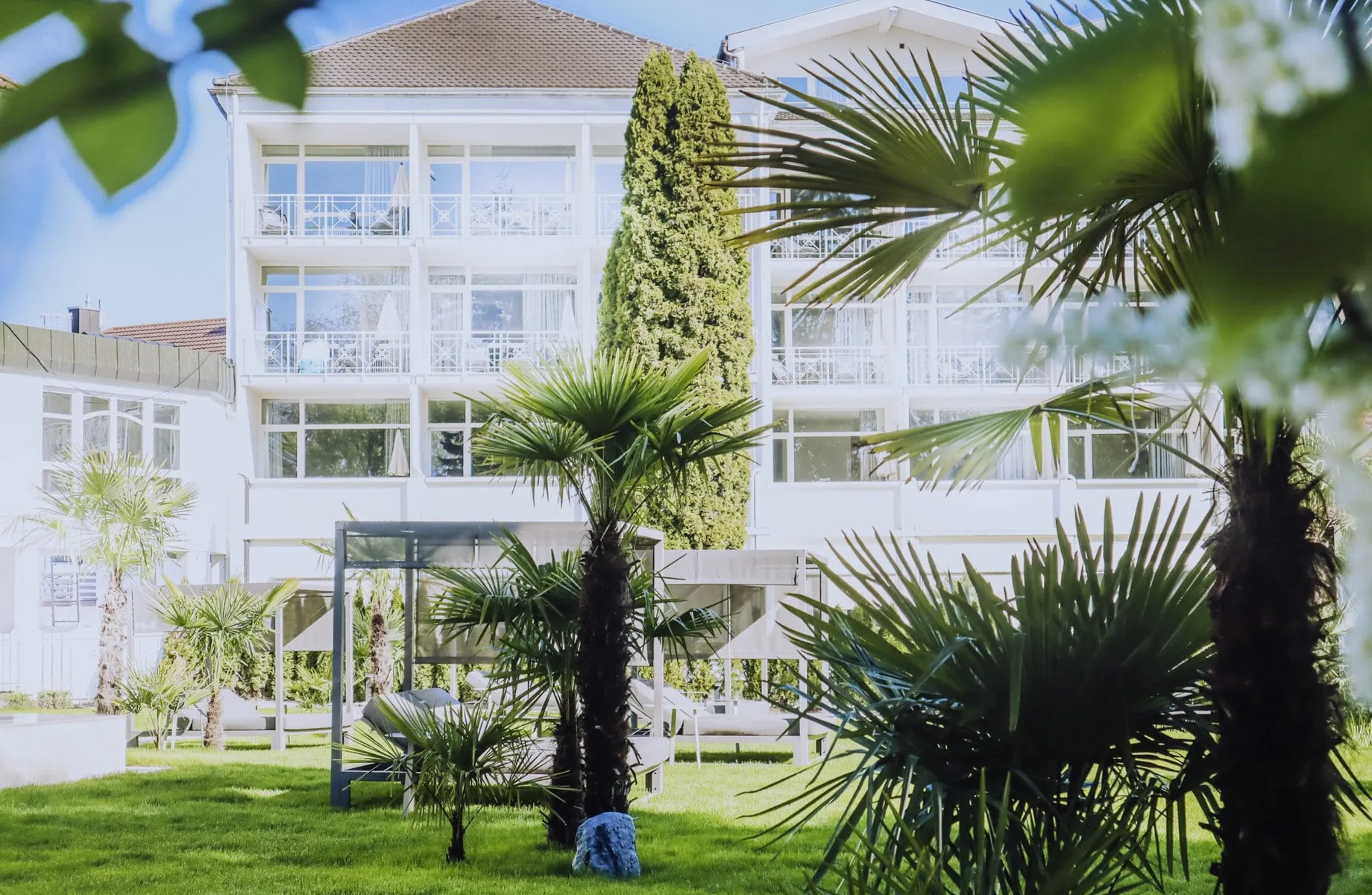 Blick vom Park mit Palmen des Das Parkhotel aus auf die Fassade