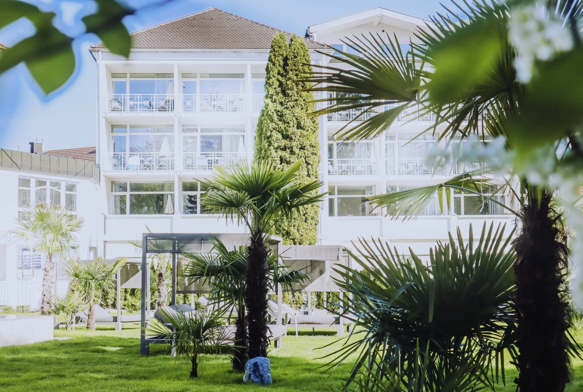Blick vom Park mit Palmen des Das Parkhotel aus auf die Fassade