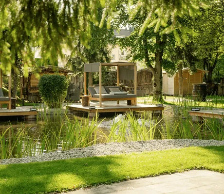 Blick in den Park im Das Parkhotel mit Naturteich und Daybeds