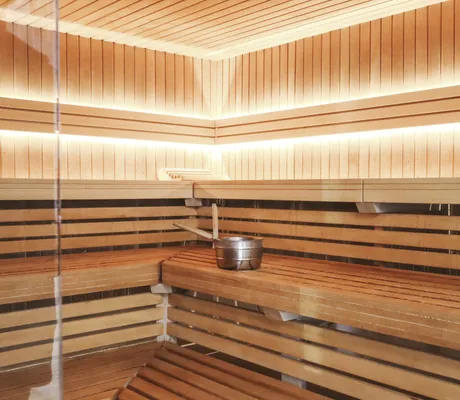 Sauna mit beleuchteten Holzwänden und Aufgusstopf im Das Parkhotel
