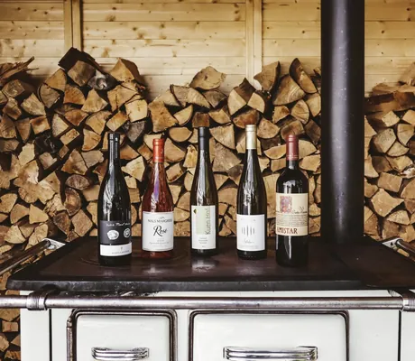 verschiedene Weinflaschen auf einem alten Herd vor Holzscheiten im Das Parkhotel