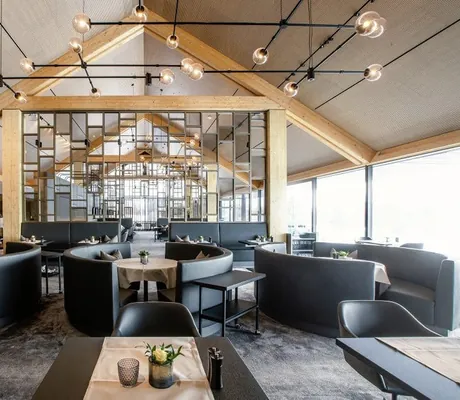 Esszimmer im Der Öschberghof mit hoher Balkendecke und blauen Sitzecken