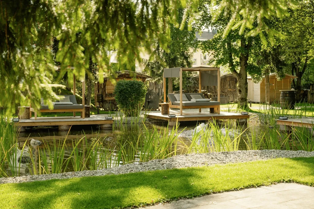 Blick in den Park im Das Parkhotel mit Naturteich und Daybeds