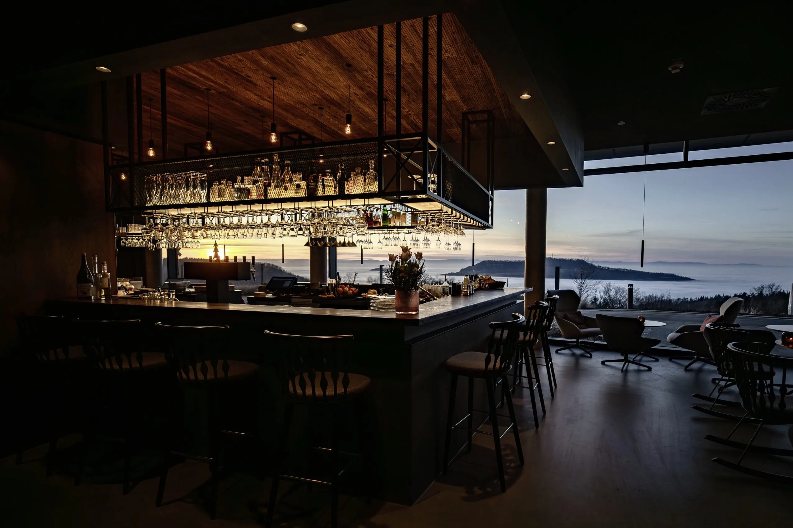 Bar im Resort Luisenh&ouml;he mit h&auml;ngenden Gl&auml;sern und Panoramablick auf Sonnenuntergang