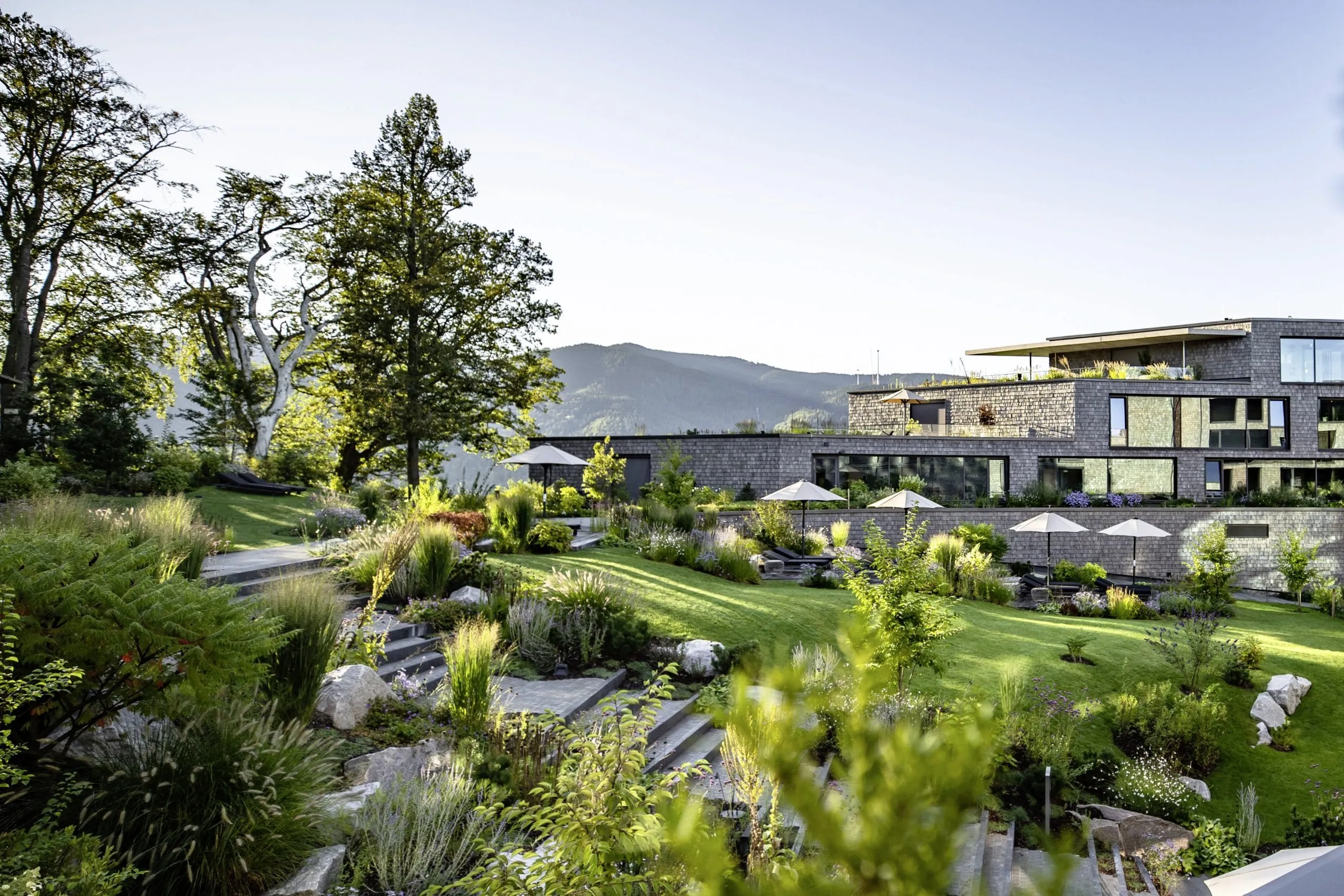 Naturgarten des Gesundheitsresorts Luisenh&ouml;he mit terrassierten Gr&uuml;nfl&auml;chen und Schwarzwald-Bergkulisse