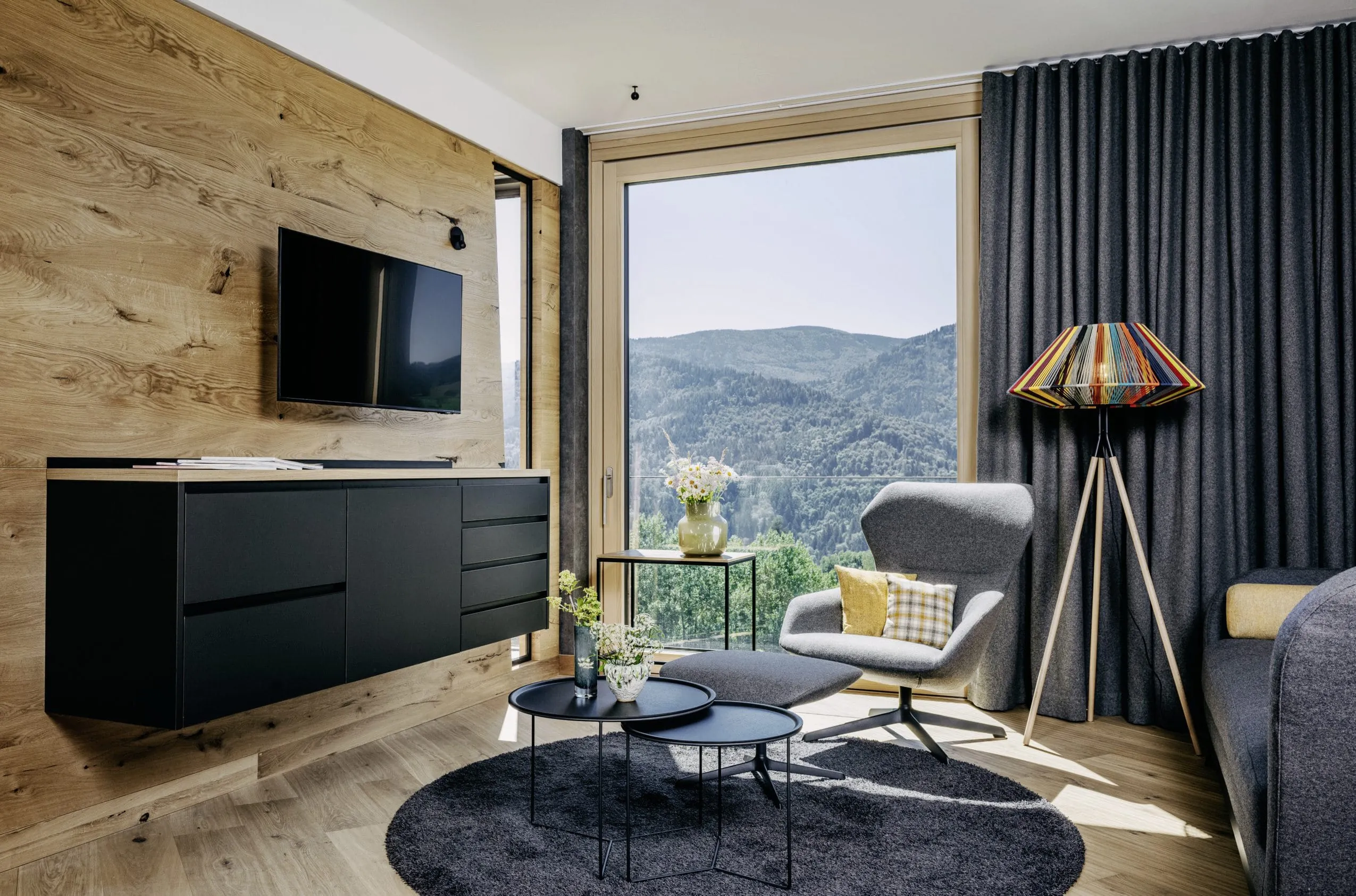 Suite im Gesundheitsresort Luisenh&ouml;he im Schwarzwald mit grauem Sessel, Panoramafenster und Schwarzwald-Blick
