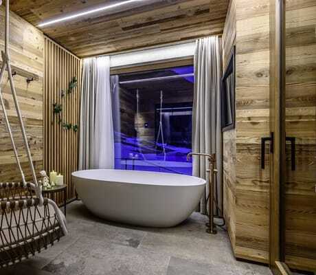 freistehende Badewanne im The Peak Sölden mit Hängekorbsessel