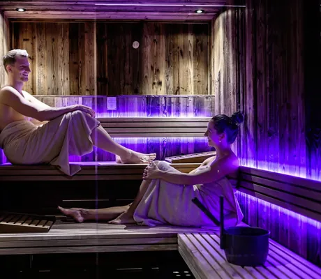Paar sitzt umhüllt von Handtüchern in der privaten Sauna des The Peak Sölden