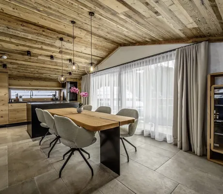 Wohnbereich des The Peak Sölden mit Holzesstisch und Küchenzeile